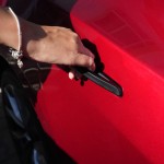 La mano de una dama sosteniendo la manija de la puerta de Tesla