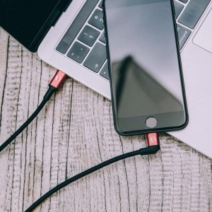 Cabo Type-C para Lightning ligado entre um Macbook e um iPhone